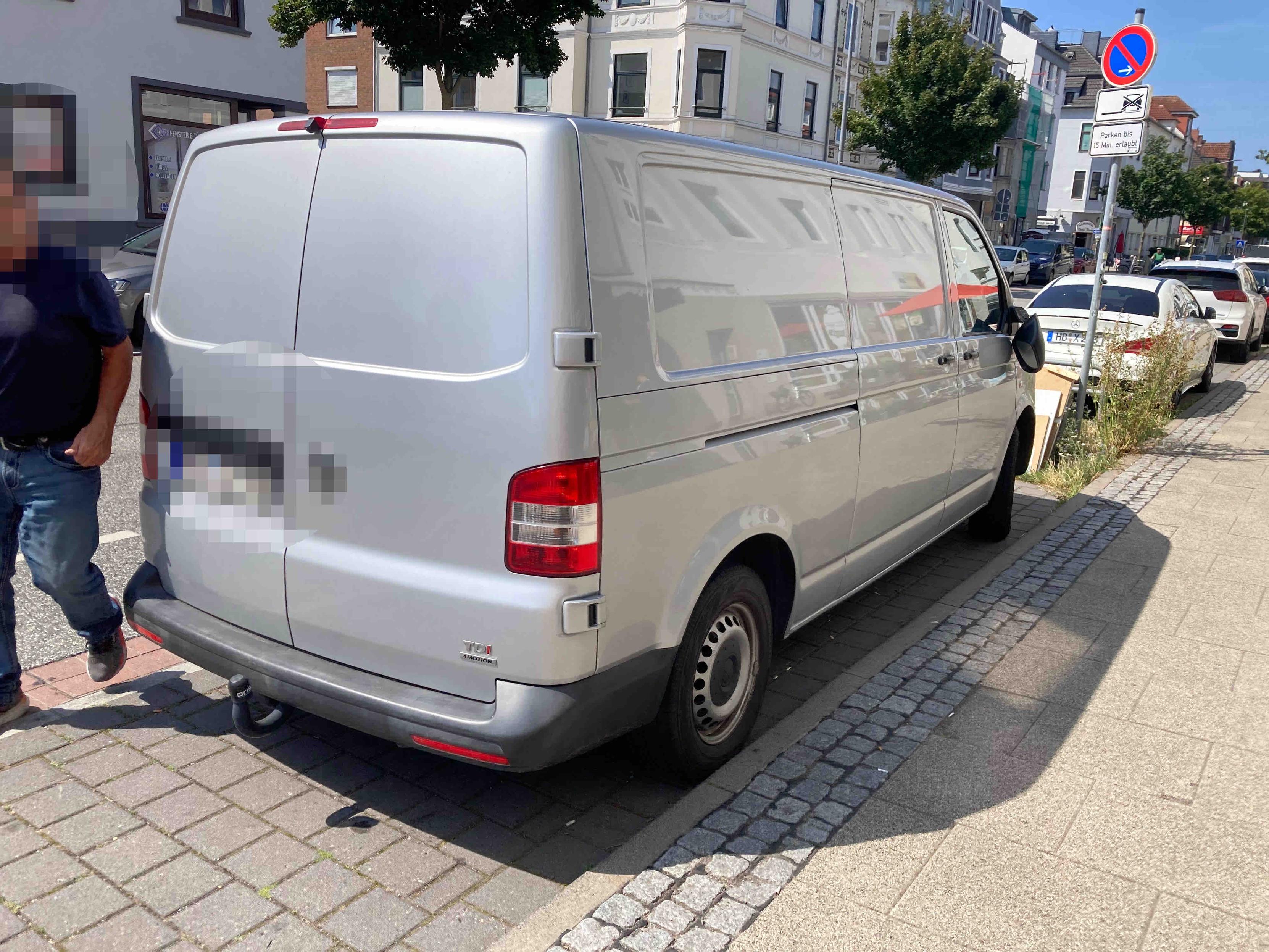 Eingeparkter Transporter, bei dem der rechte Spiegel nur noch abgebrochen an Kabeln hängt.