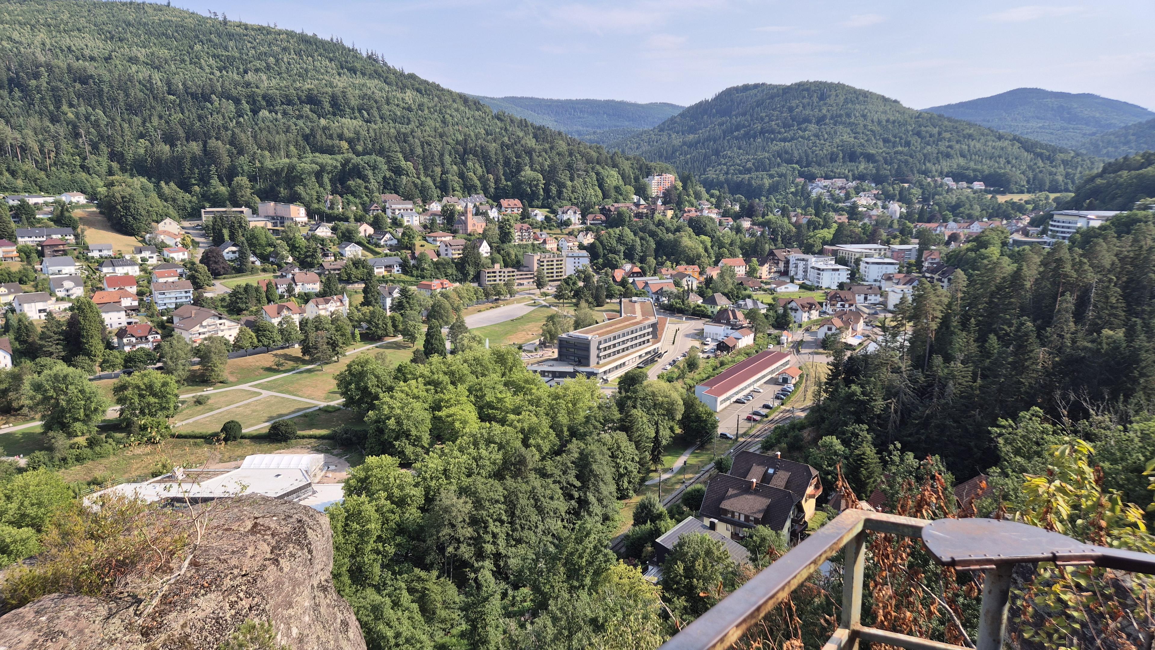 Blick vom Aussichtspunkt ins Tal zur Stadt hinunter.
Die Ortschaft ist von bewaldeten Bergen umgeben.