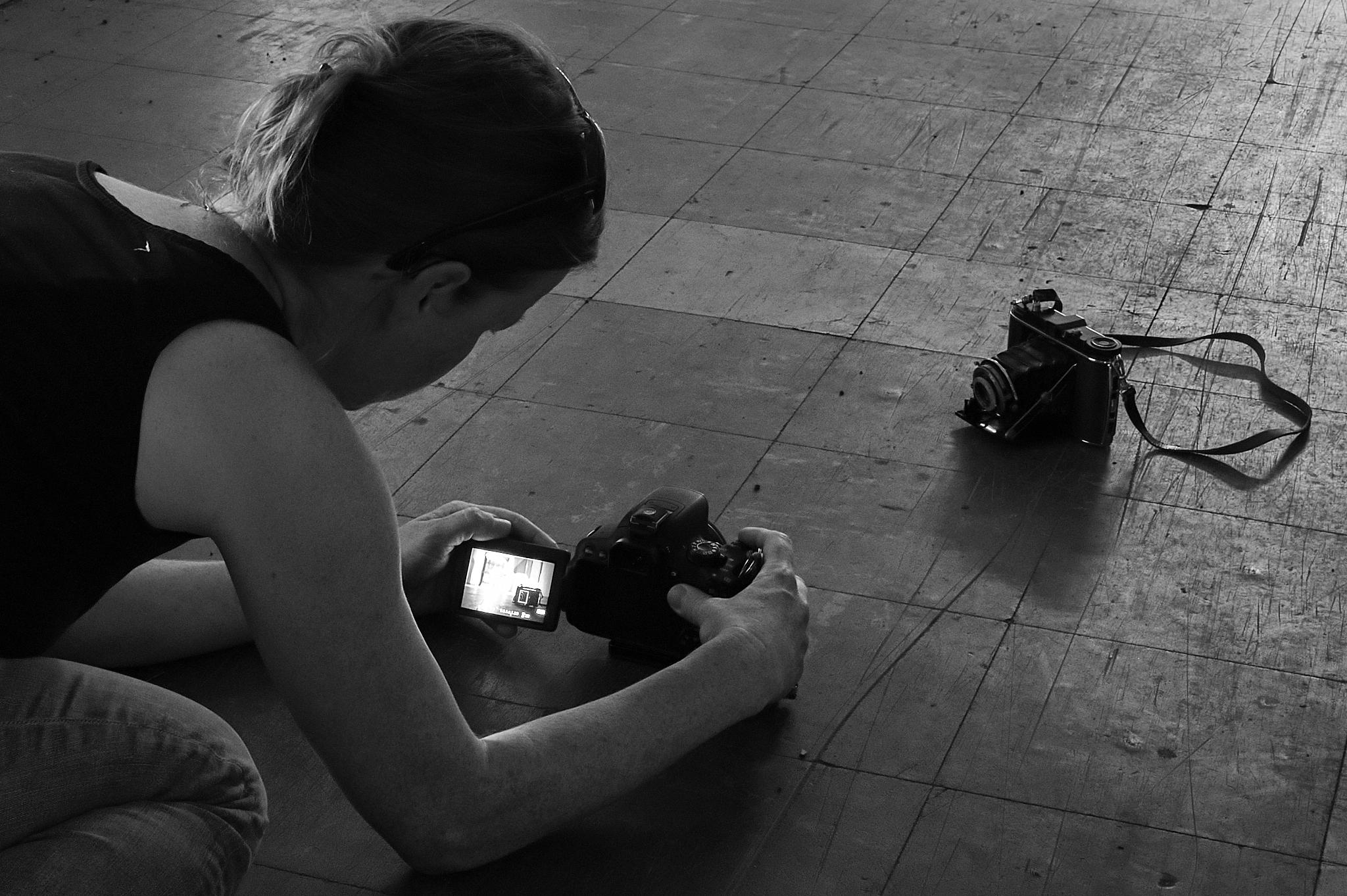 Anika fotografiert eine alte Kamera (Baujahr 1939!), die auf dem Fußboden steht.