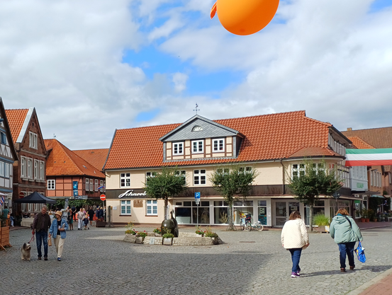 Platz in der Hitzacker Altstadt ohne Autos, mit einem organgenen Luftbalon.
