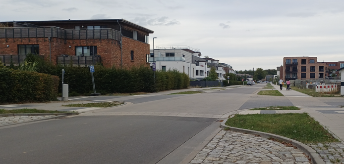 Lange gerade Straße mit vielen Parkplätzen