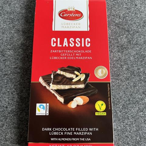Verpackung einer Schokoladentafel der Firma Carstens

"ZARTBITTERSCHOKOLADE GEFÜLLT MIT LÜBECKER EDELMARZIPAN"

"DARK CHOCOLATE FILLED WITH LÜBECK FINE MARZIPAN"

Kleiner darunter:
"WITH ALMONDS FROM THE USA"